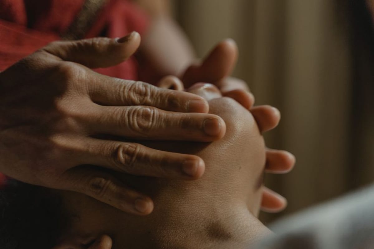 Hands performing a facial massage, face not visible