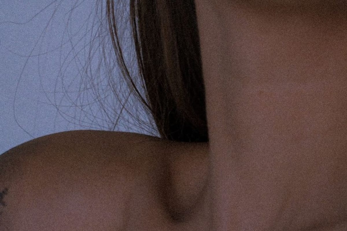 A close crop of a neck and shoulder in soft daylight