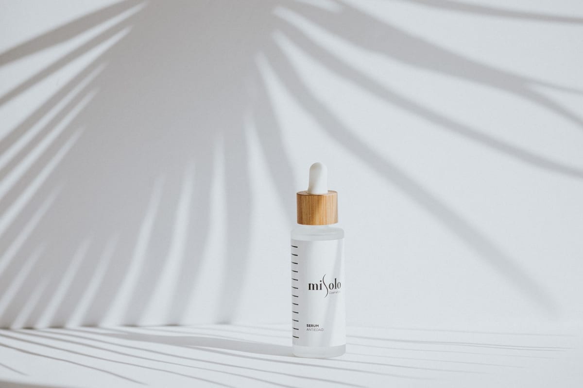 A minimal cosmetic serum bottle casting soft shadows